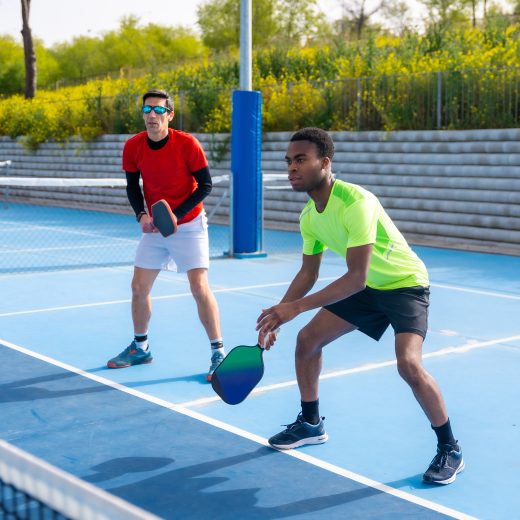 Multiracial team of pickleball players in an outdoor court Full length photo of a multiracial team of pickleball players in an outdoor court in a sunny day